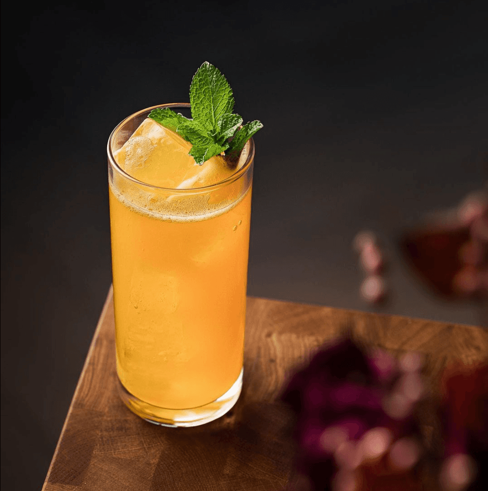 A peach-toned highball with mint garnish